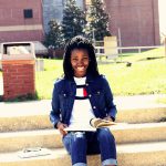Photo of a woman with a book smiling