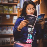 Image of a woman reading a book on computer science