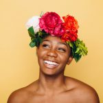 Smiling Black woman in a flower crown.