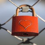 red lock with heart on a fence
