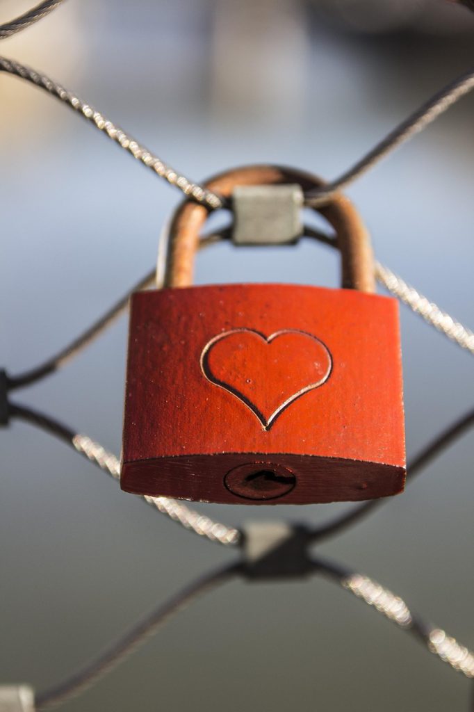 red lock with heart on a fence
